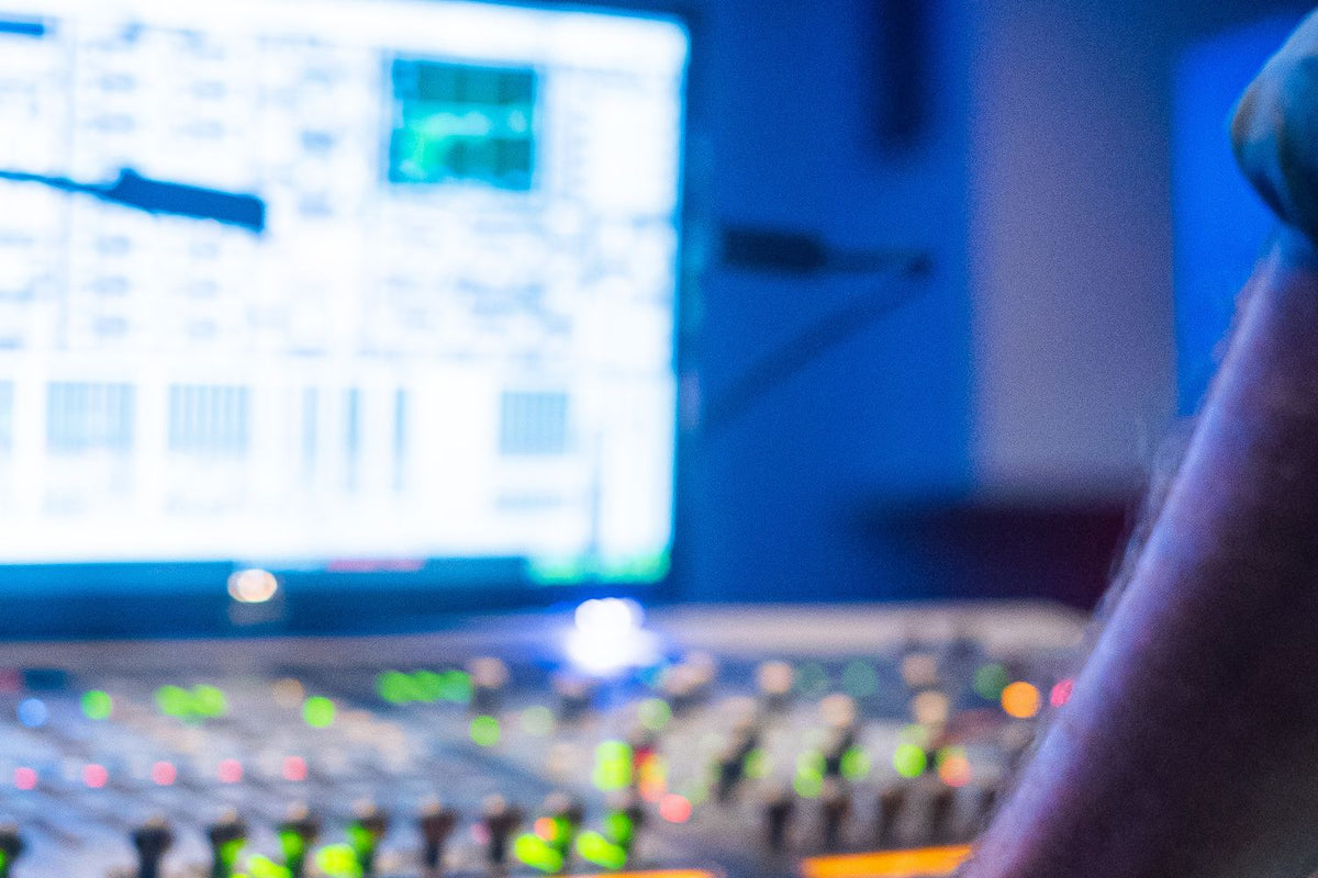Audio engineer mixing vocals on a studio console