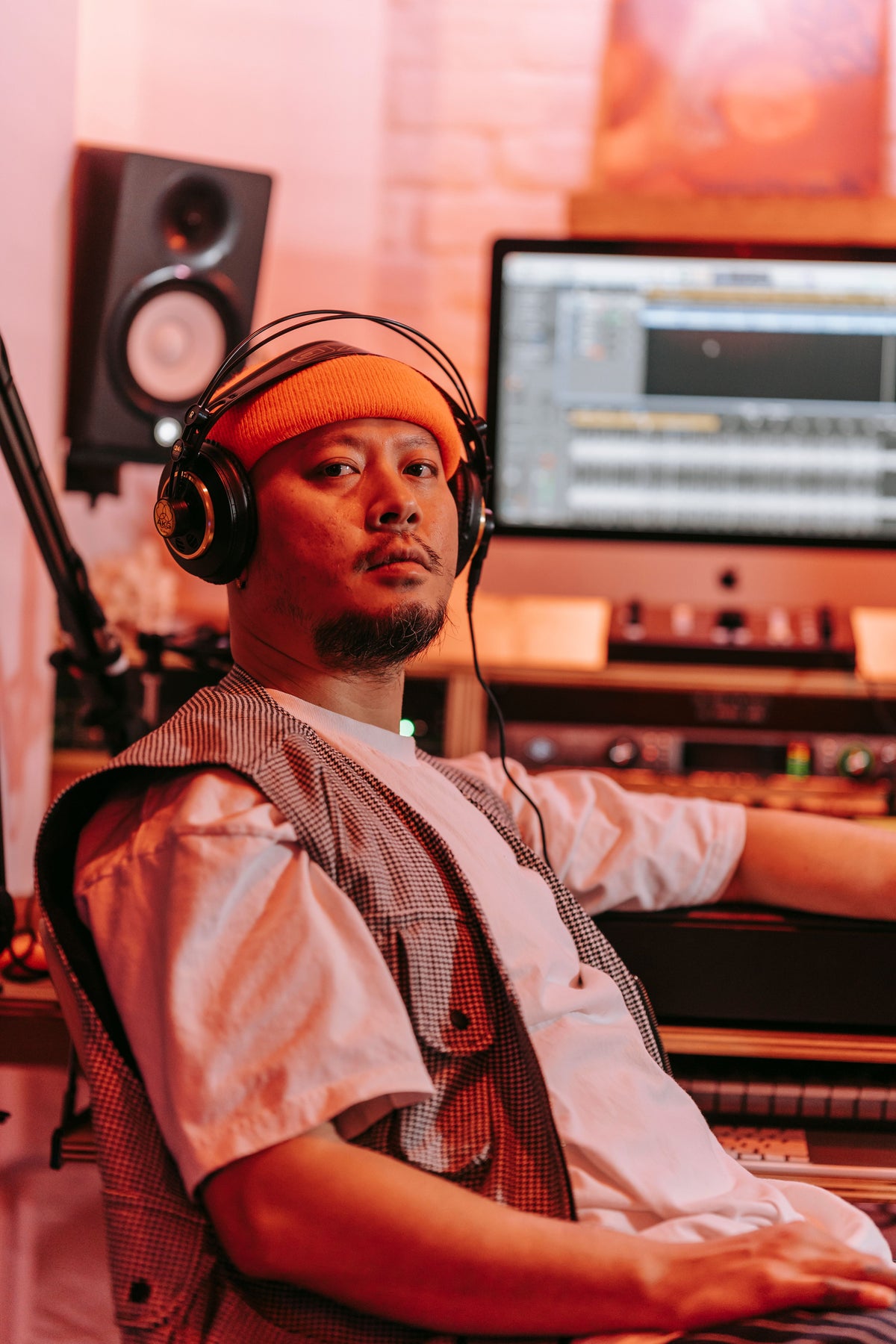 Music producer at mixing board explaining licensing and production terms