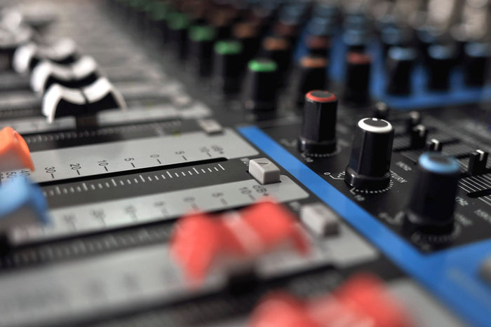 Close up of an audio mixing soundboard with stems