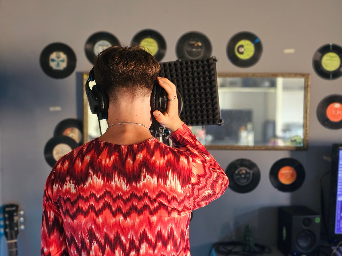 Home recording studio with vinyl records on wall and microphone setup