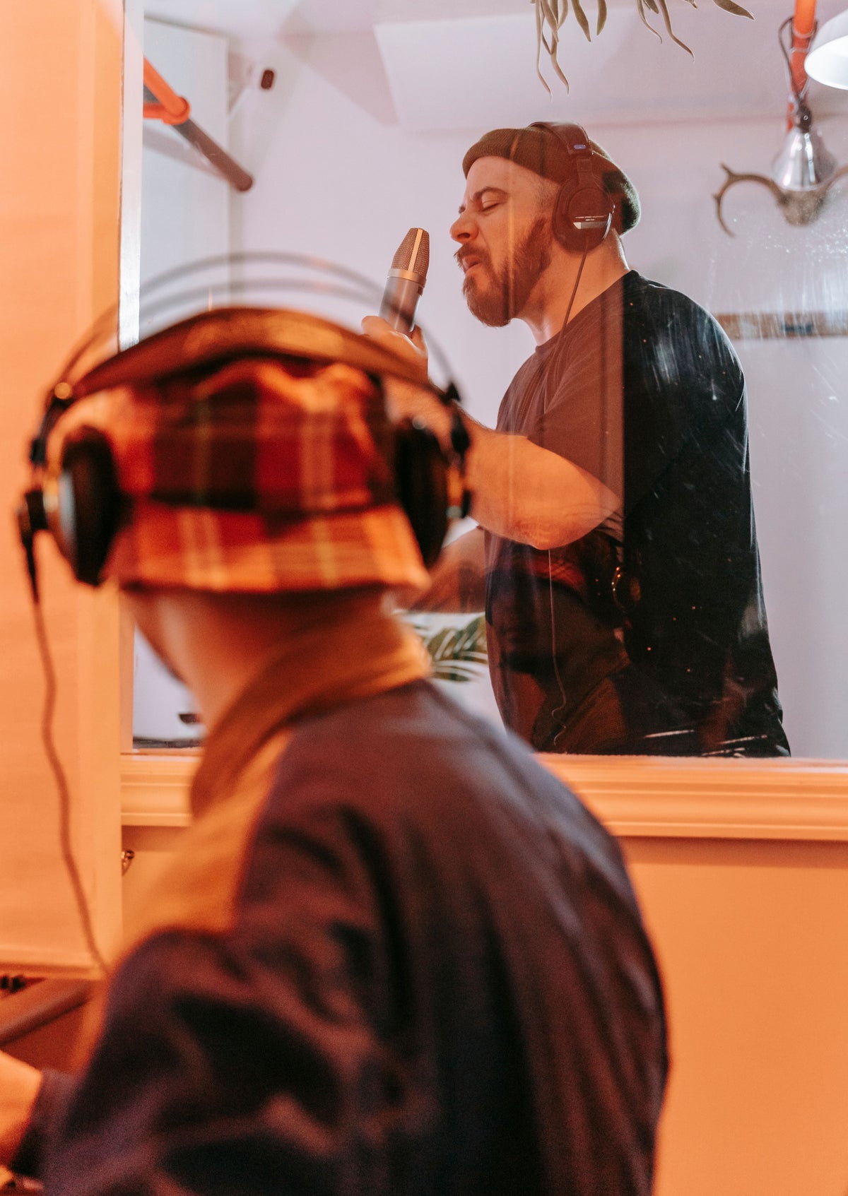 Close-up of independent artist recording in professional studio booth
