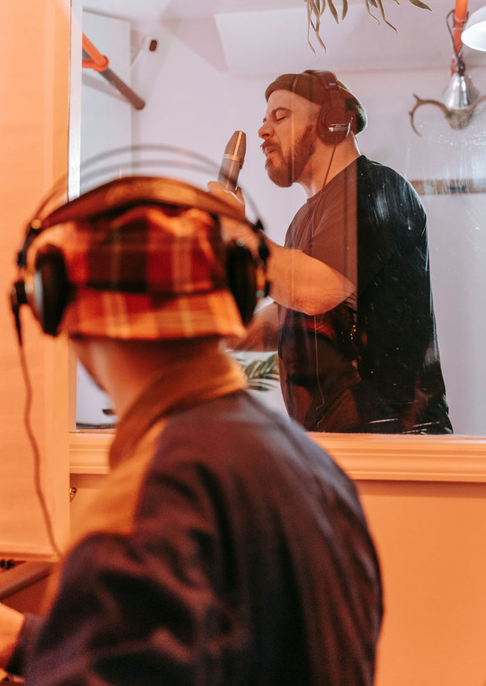Close-up of independent artist recording in professional studio booth