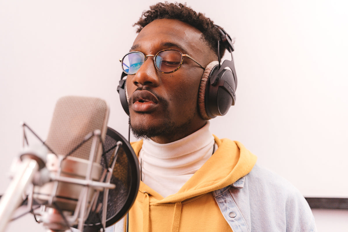 Rapper recording at studio microphone with headphones