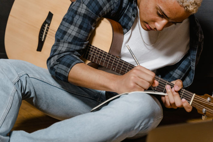 Songwriter writing lyrics in a notebook in the studio